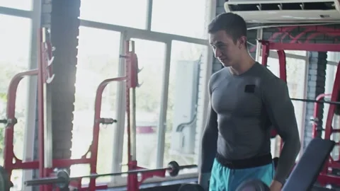 Handsome athletic man performing Curl exercise with dumbbells at gym Stock Footage 143517951