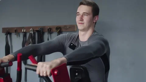Handsome athletic man performing exercide on training apparatus machine in gym Stock Footage 143516659