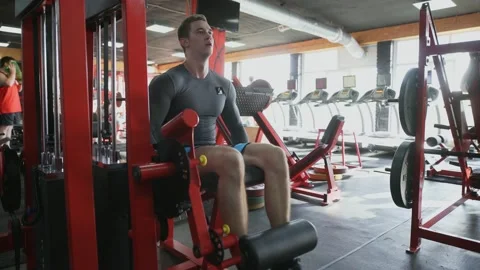 Handsome athletic man performing Leg extension at gym Vídeos de archivo 142670201