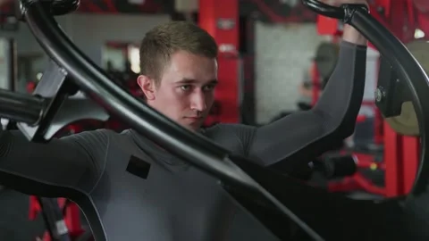 Handsome athletic man performing press on Strength Trainer machine at gym Stock Footage 143522352