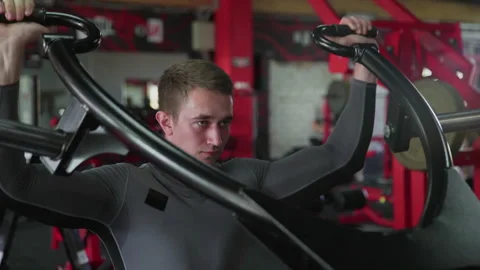 Handsome athletic man performing press on Strength Trainer machine at gym Stock-Footage 180188188