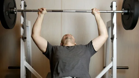 Handsome athletic man performs bench press on the bench in the gym Stock-Footage 123546850