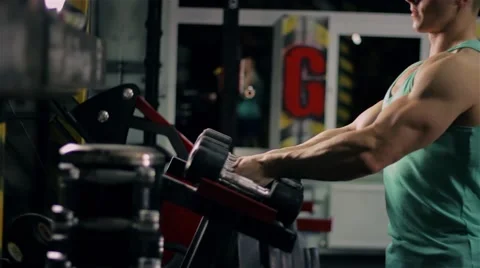Handsome athletic man taking dumbbells and go to the bench to do sport exercize Stock Footage 63220491