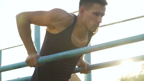 Handsome athletic man training on parallel crossbars, physical strength, health Video stock 83065204