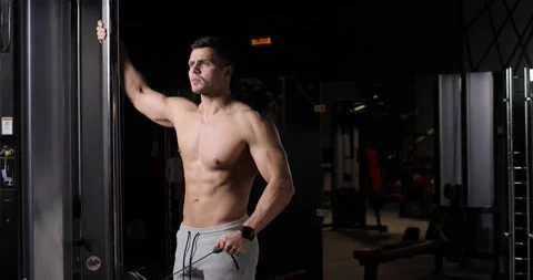 Handsome athletic young man doing exercises for biceps and triceps using a Stock Footage 160208605