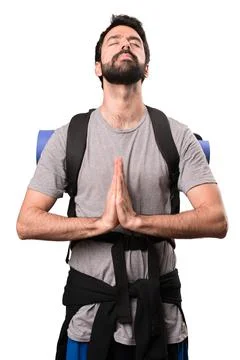 Handsome backpacker in zen position on white background Stock Photos