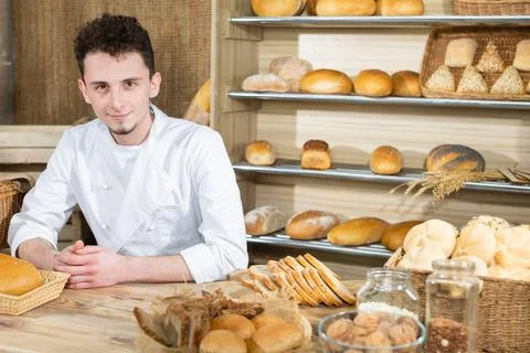 A handsome baker serves fresh bread to thirsty customers. Sale of bread in a Stock-Fotos