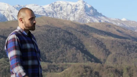Handsome bald hiker, in nature eats a bread at beautiful mountain landscape. Stock Footage 76111966