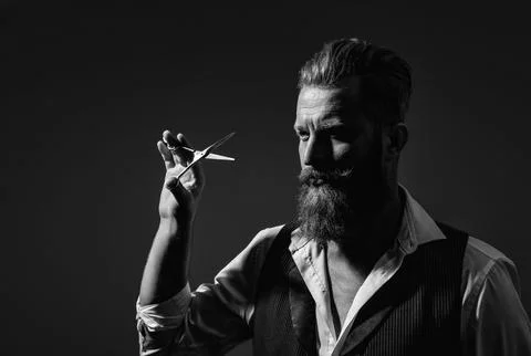 Handsome barber using scissors while cutting hair. Modern barbershop haircut Foto stock
