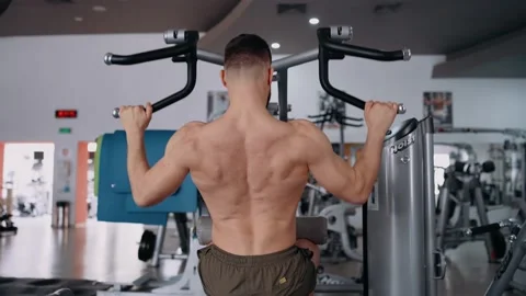 The handsome, bare-backed bodybuilder pumps his back muscles into the gym Stock Footage 156861198