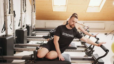 Handsome beard male instructor showing stretch exercise his females clients Stock Footage 228849061