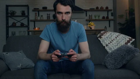 Handsome beard man playing video games at home. Loosing game, beating joystick.  Stock-Footage 108860425