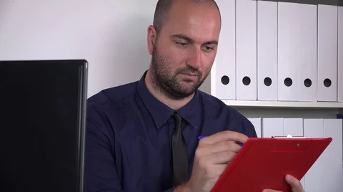 Handsome bearded accountant office worker writing in clipboard checking monitor Stock Footage