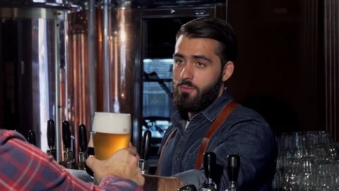 Handsome bearded bartender drinking beer with his customer Stock Footage 103052718
