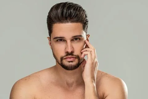 Handsome bearded brunet man posing shirtlesss, looking at the camera. Male's Stock Photos