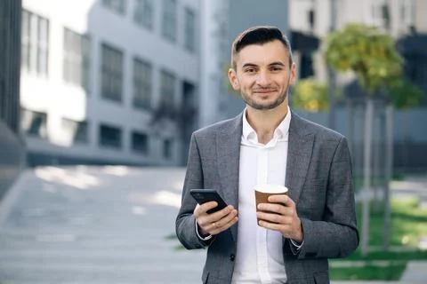 Handsome bearded businessman using mobile phone. Young man texting messages Stock Photos