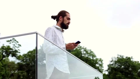 Handsome bearded businessman using smartphone outside reading message tapping Vidéo 135372799