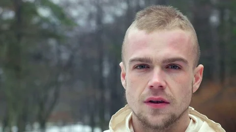 Handsome bearded caucasian guy looking serious in camera outside in the park. 4k Video stock 77569066