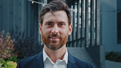 Handsome bearded caucasian man looking away turns to camera close-up successful Stock Footage 209456885