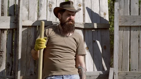 Handsome bearded farmer working with spud on spring field. Retro advertising of Stock Footage 108606694
