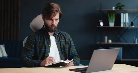 Handsome Bearded Freelancer or Student using Laptop, studying online, working Stock Footage 143294219