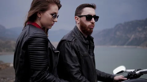 Handsome bearded guy in black jacket hugs pretty lady Stock Footage 111618350