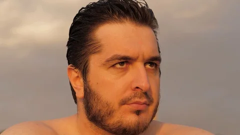 Handsome bearded guy turns head and looks straight closeup Stock Footage 124024299