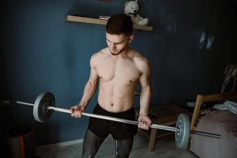 Handsome bearded guy working out at home Stock Photos