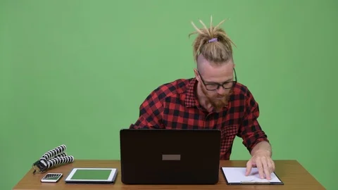 Handsome bearded hipster man multi-tasking work against wooden table Stock Footage 94739685