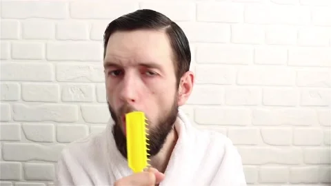 Handsome bearded man in bathrobe singing with comb having fun close up Stock-Footage 153005370