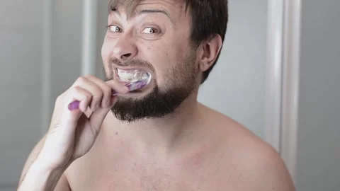 Handsome bearded man brushing his teeth Stock Footage 155935278