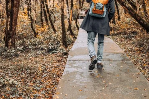 Handsome, bearded man in coat with backpack enjoys stroll through beautiful Stock Photos