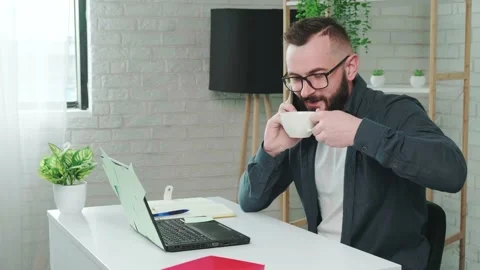 Handsome bearded man drinking coffee while talking on a smart phone. Stock Footage 154424318