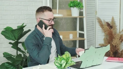 Handsome bearded man drinking coffee while talking on a smart phone. Stock Footage 154905478