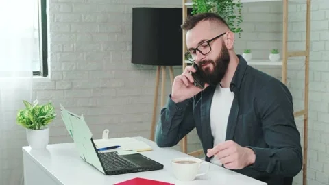 Handsome bearded man drinking coffee while talking on a smart phone. Stock Footage 158451029