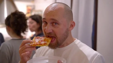 Handsome bearded man eats homemade pizza, slow-motion 動画素材 277516302