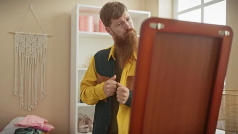 Handsome bearded man evaluating his outfit in the mirror inside a tailor sh.. Video stock 271023297