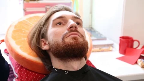 Handsome bearded man getting his beard done at the beauty studio.  Stock Footage 74158105