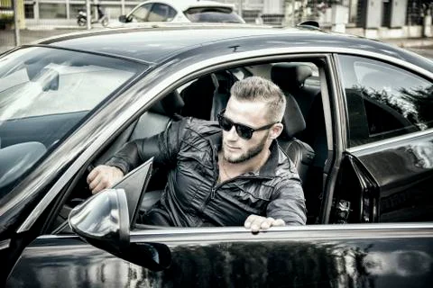 Handsome bearded man going out of car in sunglasses Stock Photos