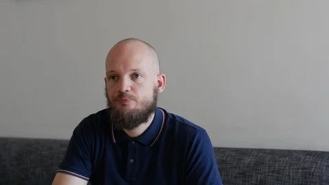Handsome bearded Man happily drinking orange juice in air-bnb home hotel style Stock Footage 112028937