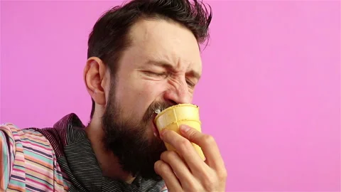 Handsome bearded  man hipster eats delicious ice cream on pink background Stock Footage 129942056