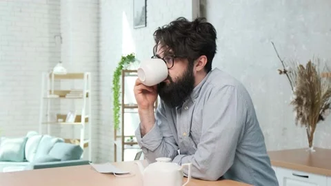 Handsome bearded man in the kitchen enjoy a cup of tea after a hard work day Stock Footage 156327852