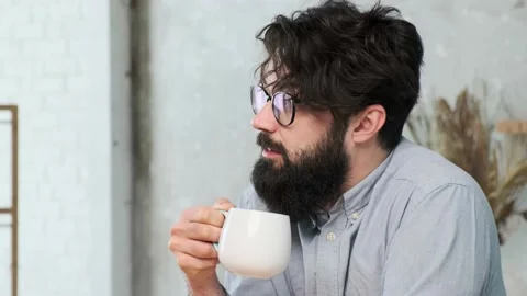 Handsome bearded man in the kitchen enjoy a cup of tea after a hard work day Stock Footage 158451121