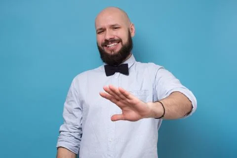 Handsome bearded man making stop sign refusing to drink alcohol on party. Stock Photos
