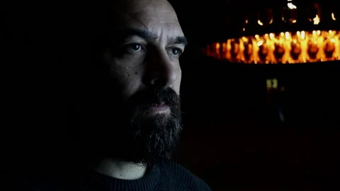 Handsome bearded man opens his eyes in a dark room Stock Footage 142817169