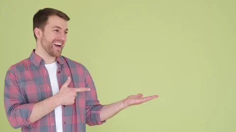 Handsome bearded man over isolated background pointing to side to present Vídeo Stock 250174859