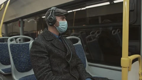 Handsome bearded Man with a protective mask sitting at the public transport Stock Footage 168285911