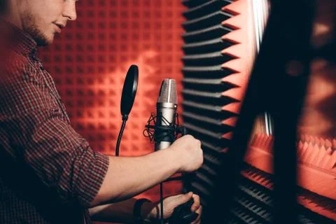 Handsome bearded man regulating the microphone in the studio Stock Photos