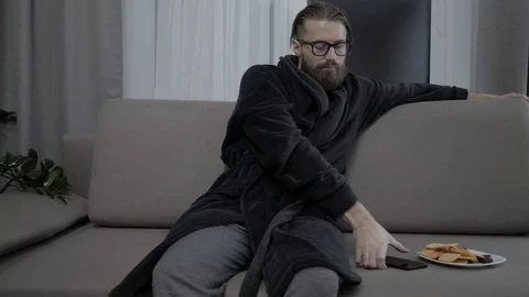 Handsome bearded man relaxing on sofa Stock Footage 104304845