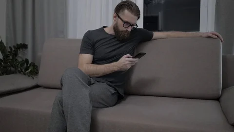 Handsome bearded man relaxing on sofa Video stock 104305187
